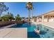 Resort-style pool area featuring a rock waterfall and lush landscaping for relaxing outdoors at 26242 S Thistle Ln, Sun Lakes, AZ 85248