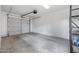 Spacious garage with a roll up door, concrete flooring, and shelving for storage at 2715 E Windsor Ave, Phoenix, AZ 85008