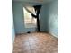 Bedroom featuring tile flooring, a bright window with hanging curtains, and blue painted walls at 2912 E Monroe St, Phoenix, AZ 85034