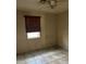 Cozy bedroom featuring a ceiling fan, window with dark blinds, and tiled floors at 2912 E Monroe St, Phoenix, AZ 85034