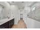 Modern bathroom with dual vanity, tiled shower, and wood tile floors at 31783 N 130Th Ave, Peoria, AZ 85383