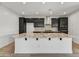 Modern kitchen with a large island, granite countertops, stainless steel appliances, and dark cabinets at 31783 N 130Th Ave, Peoria, AZ 85383