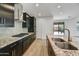 Contemporary kitchen featuring granite counters, stainless steel appliances, dark cabinetry, and tile backsplash at 31783 N 130Th Ave, Peoria, AZ 85383