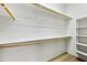 A walk-in closet includes shelving on one side and a hanging rod along the other, with wood floors at 33505 N 25Th Ave, Phoenix, AZ 85085