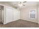 Bright bedroom with ceiling fan, carpet flooring, window with blinds, and large closet with sliding doors at 3613 W Camino Real --, Glendale, AZ 85310