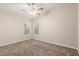 Bedroom featuring neutral walls, carpet flooring, a ceiling fan and a large window with adjustable blinds at 3613 W Camino Real --, Glendale, AZ 85310
