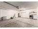 Spacious garage with roll up door, side-by-side laundry, and concrete flooring at 3613 W Camino Real --, Glendale, AZ 85310