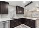 Updated kitchen showcasing dark cabinets, quartz counters, stainless steel appliances, and wood-look floors at 3613 W Camino Real --, Glendale, AZ 85310