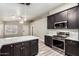 Well-lit kitchen featuring dark cabinetry, stainless steel appliances, and sleek quartz countertops at 3613 W Camino Real --, Glendale, AZ 85310
