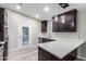 Modern kitchen with dark cabinets, quartz countertops, stainless steel appliances, and backyard access at 3613 W Camino Real --, Glendale, AZ 85310