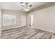 Bright living room with wood-look floors, a ceiling fan, and a view of the entrance and closet at 3613 W Camino Real --, Glendale, AZ 85310