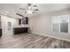 Living area with wood-look flooring, a ceiling fan, and an open view into the adjacent kitchen at 3613 W Camino Real --, Glendale, AZ 85310