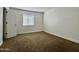 Bright bedroom features a neutral color palette, brown carpet, and natural light from a window at 3825 E Camelback Rd # 292, Phoenix, AZ 85018