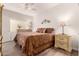 Inviting bedroom with a patterned bedspread, wood-look floors, and two nightstands with lamps at 3830 E Lakewood Pkwy # 2116, Phoenix, AZ 85048