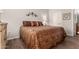 Comfortable bedroom with a patterned bedspread, wood-look floors, and decorative wall art at 3830 E Lakewood Pkwy # 2116, Phoenix, AZ 85048