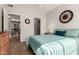Cozy bedroom with a bed featuring teal linens, wood-look floors, and walk-in closet access at 3830 E Lakewood Pkwy # 2116, Phoenix, AZ 85048
