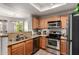 Well-equipped kitchen with stainless steel appliances, granite countertops, and wood cabinets at 3830 E Lakewood Pkwy # 2116, Phoenix, AZ 85048