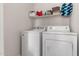 Bright laundry room features a white washer and dryer set with shelf overhead for storage at 3830 E Lakewood Pkwy # 2116, Phoenix, AZ 85048