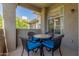 Cozy covered outdoor patio features a round table and four cushioned chairs at 3830 E Lakewood Pkwy # 2116, Phoenix, AZ 85048