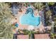 Aerial view of a community pool with lush landscaping, lounge chairs, and a central fire feature at 3830 E Lakewood Pkwy # 2116, Phoenix, AZ 85048