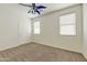 This bedroom features plush carpeting, a cooling fan, and a door with neutral tones that offer plenty of natural light at 42209 N 46Th Ln, Phoenix, AZ 85086