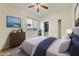 This primary bedroom features plush carpeting, a cooling fan, and beautiful artwork that adds character and charm to the room at 42209 N 46Th Ln, Phoenix, AZ 85086