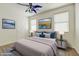 This bedroom features plush carpet, a cooling fan, and beautiful artwork that adds character and charm to the room at 42209 N 46Th Ln, Phoenix, AZ 85086