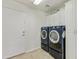 Well-lit laundry room with a side-by-side washer and dryer set and white storage cabinets at 42209 N 46Th Ln, Phoenix, AZ 85086