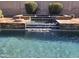 This backyard features a luxurious pool with a multi-tier waterfall and well-manicured landscaping at 42209 N 46Th Ln, Phoenix, AZ 85086