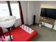Bedroom with a red bedspread, carpeted floors, and a TV on top of a wood table at 4650 E Wood St, Phoenix, AZ 85040
