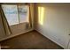 Bedroom with natural lighting, neutral walls, carpeted floors, and an electrical outlet at 4650 E Wood St, Phoenix, AZ 85040