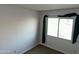 Cozy bedroom with neutral walls, carpeted floors, and a bright window at 4650 E Wood St, Phoenix, AZ 85040