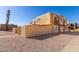 Beige stucco townhome featuring a balcony, tan privacy wall, and low-maintenance landscaping at 4650 E Wood St, Phoenix, AZ 85040