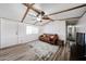 Spacious living room featuring wood-look floors, a ceiling fan, and a comfortable sofa at 652 S Ellsworth Rd # 92, Mesa, AZ 85208