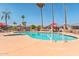 A bright community pool with multiple access ladders and lounge chairs beneath tall palms at 652 S Ellsworth Rd # 92, Mesa, AZ 85208