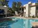 Community pool with plenty of lounge chairs and lush landscaping at 750 E Northern Ave # 2088, Phoenix, AZ 85020