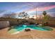 Serene backyard pool with rock accents and mature landscaping, set against a vibrant sunset backdrop at 750 S Cholla St, Gilbert, AZ 85233