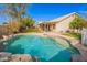 Inviting backyard pool with rock features, surrounded by a lush lawn and mature trees, perfect for outdoor relaxation at 750 S Cholla St, Gilbert, AZ 85233
