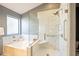 Bathroom showcasing a soaking tub with tile surround and a glass-enclosed shower with grab bars at 750 S Cholla St, Gilbert, AZ 85233