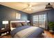 Comfortable bedroom features dark blue walls, a ceiling fan, and a large window at 750 S Cholla St, Gilbert, AZ 85233