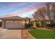 Charming single-story home with a tile roof, lush landscaping, and a two-car garage, bathed in the warm light of sunset at 750 S Cholla St, Gilbert, AZ 85233