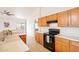 Functional kitchen featuring wooden cabinets, black appliances, and a breakfast bar, with an adjacent dining area at 750 S Cholla St, Gilbert, AZ 85233