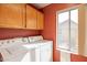 Functional laundry room with washer, dryer, wood cabinets, and natural light at 750 S Cholla St, Gilbert, AZ 85233