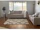 Cozy living room with comfortable sofa, modern rug, and natural light from the large window at 750 S Cholla St, Gilbert, AZ 85233