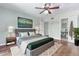 Comfortable main bedroom with a ceiling fan, a large painting, and an ensuite bathroom at 796 E Pepper Dr, Casa Grande, AZ 85122