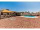 Spacious backyard with a fenced pool, a shade, and a fire pit for outdoor entertainment at 8540 N 104Th Ave, Peoria, AZ 85345