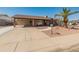 Well-maintained single-story home with a large driveway, covered carport, desert landscaping, and brick accents at 8540 N 104Th Ave, Peoria, AZ 85345