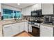 Updated kitchen featuring stainless steel appliances, white cabinetry and granite countertops at 8540 N 104Th Ave, Peoria, AZ 85345