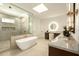 Bright bathroom boasts a soaking tub, marble counter tops, and a glass enclosed shower with copper hardware at 9900 N 52Nd St, Paradise Valley, AZ 85253