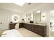 Light filled bathroom featuring dual sinks, make up vanity, light up mirrors, and stylish cabinetry at 9900 N 52Nd St, Paradise Valley, AZ 85253